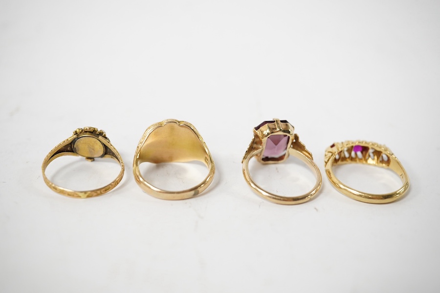 A group of four rings, comprising: a chalcedony signet ring with engraved floral shoulders, size L, partial British hallmarks for 15ct gold; a synthetic ruby and diamond five-stone ring, size N, stamped 18CT; a ring set